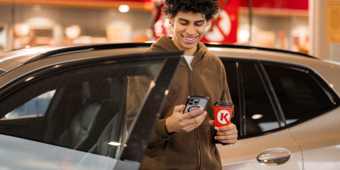 Mann lächelt und schaut auf sein Handy