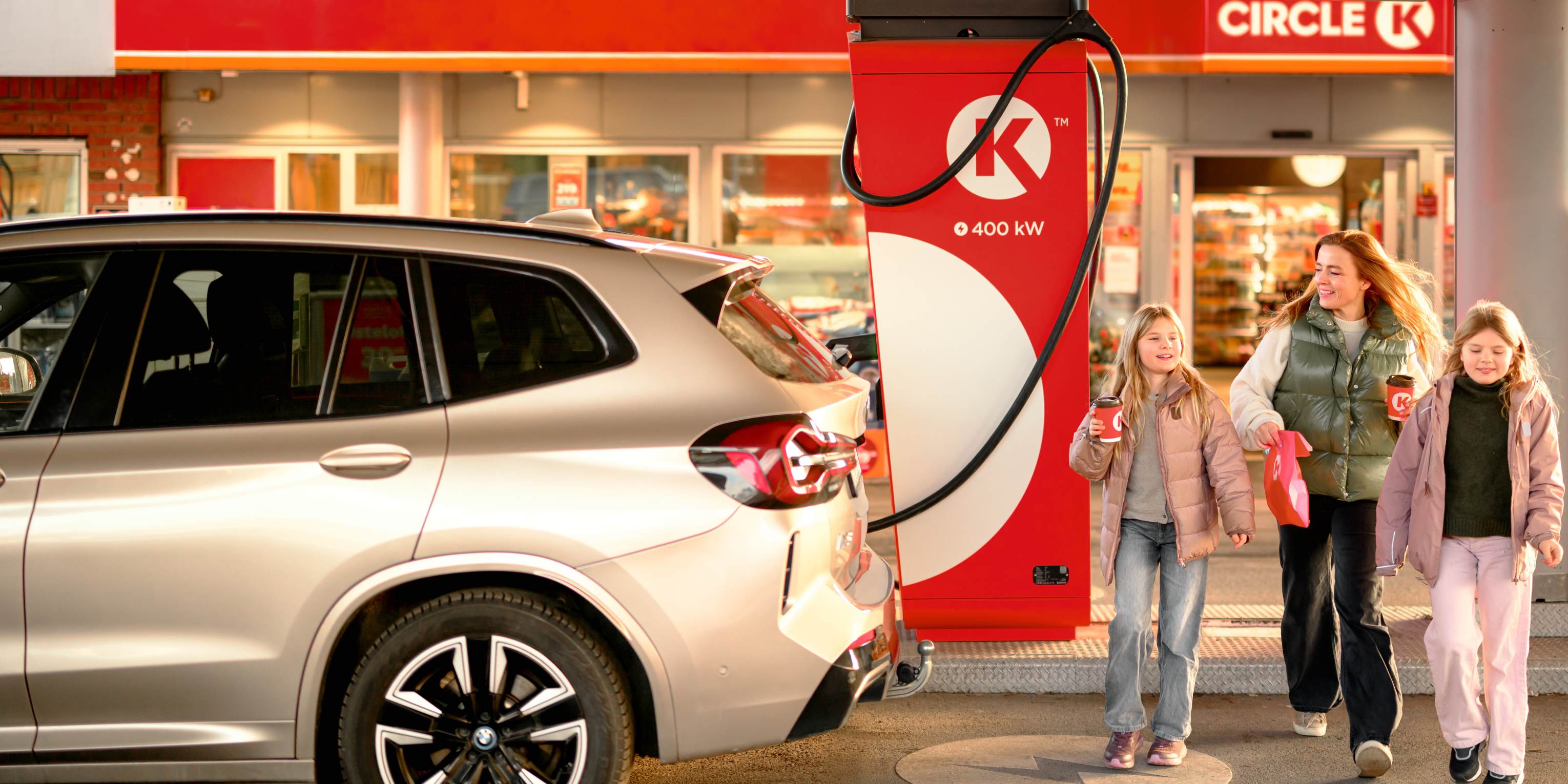 Mutter mit Kindern an einer Circle K Station im Außenbereich