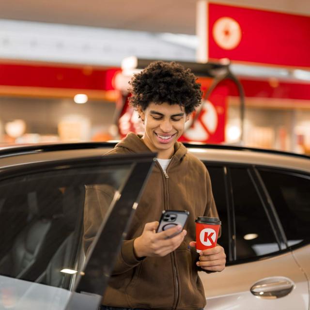 Mann lächelt und schaut auf sein Handy