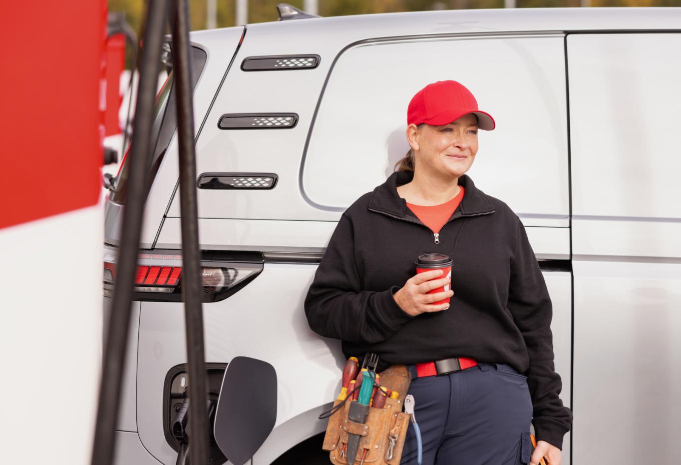 Kundin mit Circle K Kaffee lehnt an Kleinbus