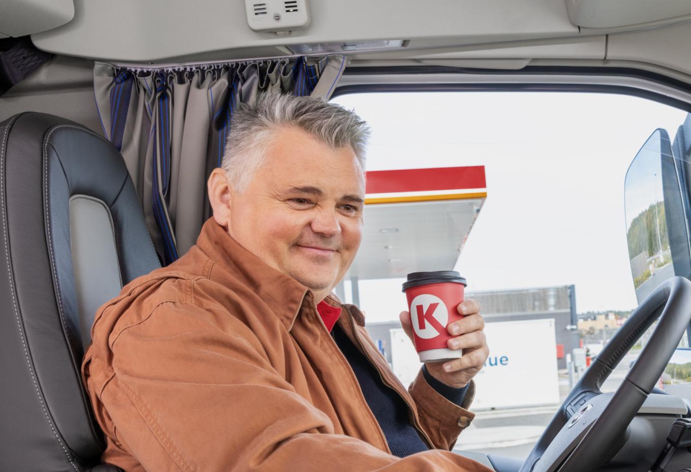 LKW-Fahrer am Steuer mit Circle K Kaffee
