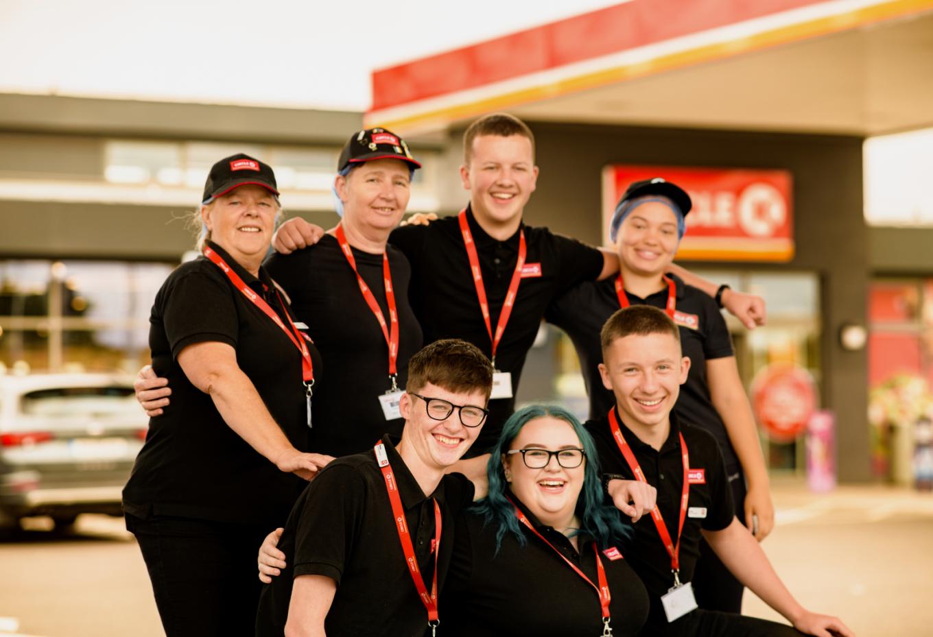 Junge MitarbeiterInnen gruppiert vor einer Circle K Tankstelle