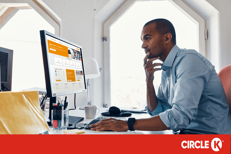 Mann in Hemd sitzt vor Bildschirm und bedient Computer mit Maus